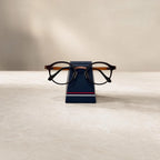 Simple Eyeglass Holder Stand lifestyle — matte navy sunglasses display stand on clean desk surface
